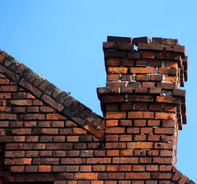 Damaged chimney on an Wilton Manors home showing cracks and missing mortar